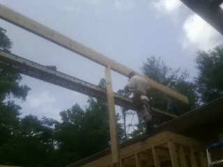 Carpenter setting a ridge beam over a new addition frame — Ice Dam Removal by Roofing Brothers in Allenspark