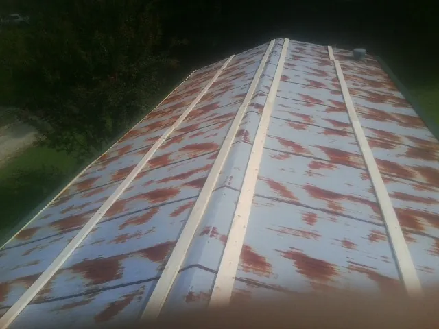 Rusted metal roof panels with new wood purlins before replacement — Storm Damage Roof Repair in Allenspark by Roofing Brothers