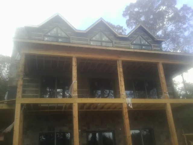 Dormers and porch framing on a large log home under construction — Roof Coating work by our crew in Allenspark