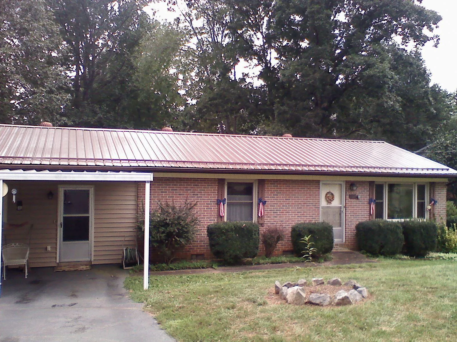 Bronze metal roof and carport on a brick ranch home — Roof Repair work by our crew in Allenspark
